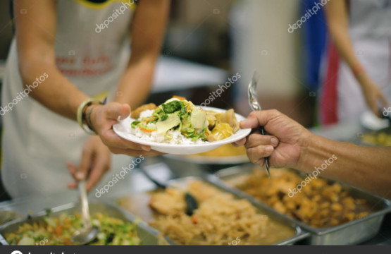 A man handing a plate of food to another person during an amazing breakfast.