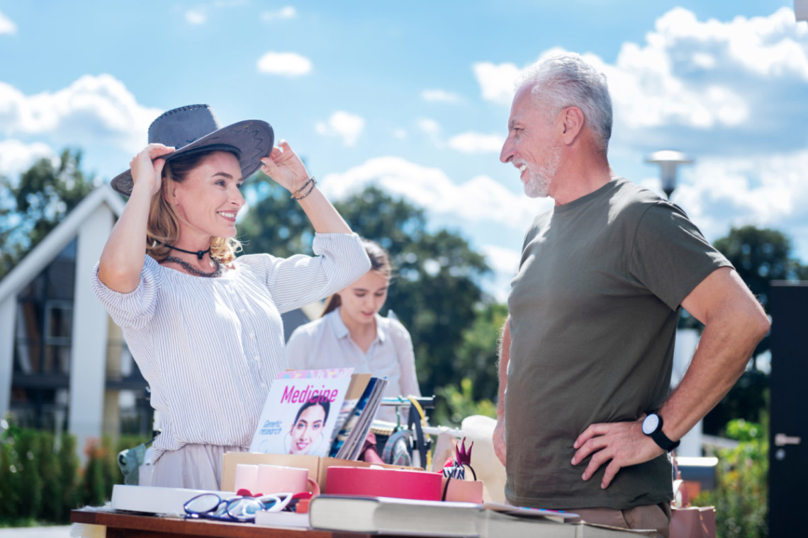 A woman is conversing with an older man at the Annual Yard Sale at Hampton Plaza.