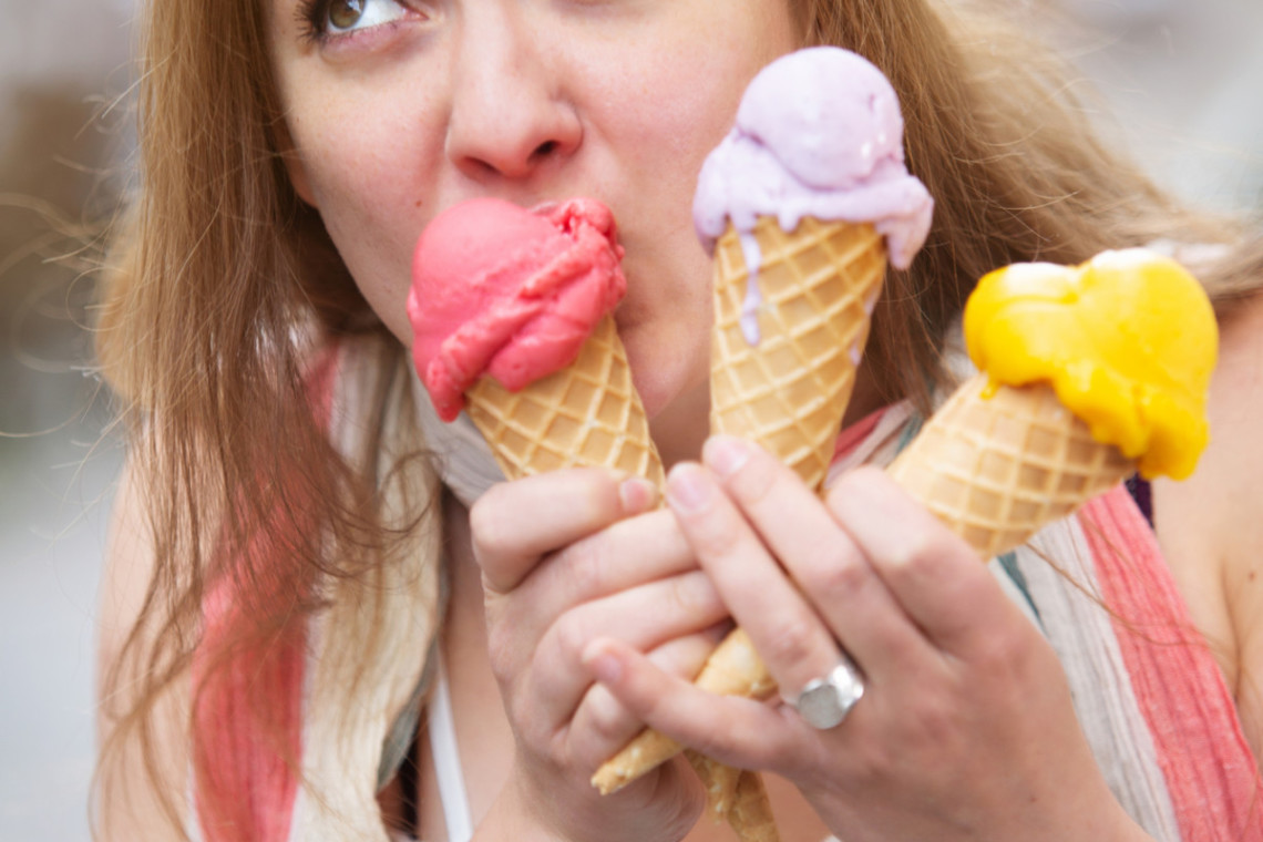 A woman enjoying ice cream cones during summertime.